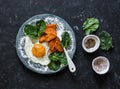 Healthy breakfast or snack - fried egg, baked sweet potato and spinach on dark background