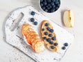 Healthy breakfast with sweet sandwiches - ricotta, blueberries, apple slices, peanut butter on white rustic wood table Royalty Free Stock Photo