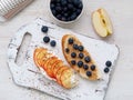 Healthy breakfast with sweet sandwiches - ricotta, blueberries, apple slices, peanut butter on white rustic wood table Royalty Free Stock Photo