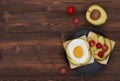 Healthy breakfast toasts with avocado and fried egg on the brown wooden background flat lay mock-up with copy space Royalty Free Stock Photo