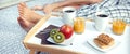 Healthy breakfast on tray and couple legs in background Royalty Free Stock Photo