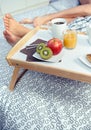 Healthy breakfast on tray and couple legs in Royalty Free Stock Photo