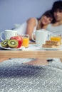 Healthy breakfast on tray and couple lying in Royalty Free Stock Photo