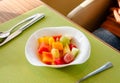 Healthy breakfast various fresh organic fruits salad in a white Bowl with fork under morning light on green table background, top Royalty Free Stock Photo