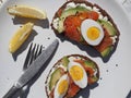 Healthy breakfast.Whole grain bread sandwiches with cream cheese, egg, avocado and salmon fish on a white wooden background. View Royalty Free Stock Photo