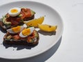 Healthy breakfast.Whole grain bread sandwiches with cream cheese, egg, avocado and salmon fish on a white wooden background. View Royalty Free Stock Photo