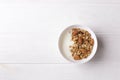 Bowl of whole grain granola with yogurt on white background, top view Royalty Free Stock Photo