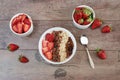 Healthy breakfast -yoghurt with oat flakes, raisins, strawberries, muesli. Fruit breakfast on a wooden background Royalty Free Stock Photo