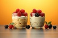 Yogurt and berry bowls with spoon and towel on bright white and yellow background, space for text