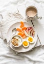 Healthy breakfast - yogurt with granola, fresh fruit apples, tangerines and coffee with milk on a light background