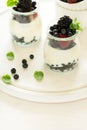 Healthy breakfast: yogurt with strawberry, blueberry and blackberry decorated mint leaves on white wooden table Royalty Free Stock Photo