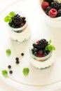 Healthy breakfast: yogurt with strawberry, blueberry and blackberry decorated mint leaves on white wooden table Royalty Free Stock Photo