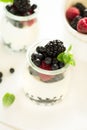 Healthy breakfast: yogurt with strawberry, blueberry and blackberry decorated mint leaves on white wooden table Royalty Free Stock Photo