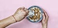 Healthy breakfast. A young woman is pouring cereals with milk. Royalty Free Stock Photo