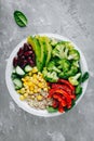 Healthy buddha bowl salad with grilled vegetables. Quinoa, spinach, avocado, beans, sweet corn, broccoli, cucumbers and paprika