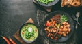 Healthy Buddha bowl salad with salmon, red quinoa, baked vegetables, micro greens and cream soup with green beans in bowl on dark Royalty Free Stock Photo