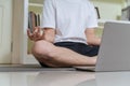 Healthy business man using laptop for learning online yoga for meditation. Businessman meditates in lotus pose for relax, relief Royalty Free Stock Photo