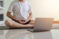 Healthy business young man doing yoga for meditation on home office floor. Businessman meditates in lotus pose for relax, relief Royalty Free Stock Photo