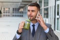 Healthy businessman drinking juice while working