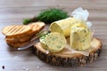 Healthy butter with dill, parsley in the form of a roll, slices for easy use. Herbal butter on a cutting board for toasted,