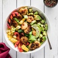 A healthy cajun prawn bowl with mixed vegetables, avocado and rice.