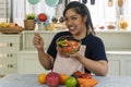 Healthy care diet concept. Chubby overweight young woman wear apron holding glass bowl with fresh organic salad vegetable Royalty Free Stock Photo