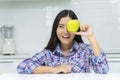 Healthy care diet or fruits concept. Attractive smiling young woman holding fresh green apple covered own eyes breakfast time Royalty Free Stock Photo