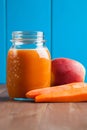 Healthy carrot apple smoothie in a jar on blue wooden background Royalty Free Stock Photo