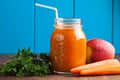 Healthy carrot apple smoothie in a jar on blue wooden background Royalty Free Stock Photo