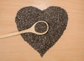 Healthy Chia seeds in the form of a heart. Chia in a wooden spoon on a wooden table close-up. Royalty Free Stock Photo