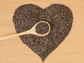 Healthy Chia seeds in the form of a heart. Chia in a wooden spoon on a wooden table close-up. Royalty Free Stock Photo