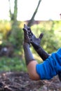 Healthy child, boy or girl, experiencing Earth materials with mud