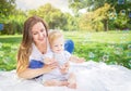 Healthy child (kid) having fun with mother and soap bubbles in a sunny summer day at the park. Royalty Free Stock Photo