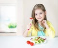 Healthy child nutrition.Girl eating salad at table. Royalty Free Stock Photo