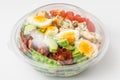 Healthy cobb salad in plastic package for take away or food delivery on white background. close up Royalty Free Stock Photo