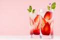 Healthy cold fruit beverage with strawberry and mineral water, mint, ice, straw in modern elegant pastel pink interior, copy space Royalty Free Stock Photo