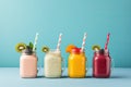 Healthy colorful smoothies in glass jars with straws on blue background, Fresh fruit smoothies in glass jars with straws on blue