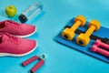 Healthy concept, diet plan with sport shoes and bottle of water and dumbbells on blue background, healthy food and Royalty Free Stock Photo