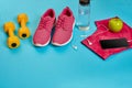 Healthy concept, diet plan with sport shoes and bottle of water and dumbbells on blue background, healthy food and Royalty Free Stock Photo