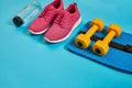 Healthy concept, diet plan with sport shoes and bottle of water and dumbbells on blue background, healthy food and Royalty Free Stock Photo