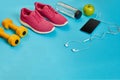 Healthy concept, diet plan with sport shoes and bottle of water and dumbbells on blue background, healthy food and Royalty Free Stock Photo