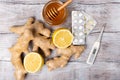 Healthy concept. Tea, lemon, thermometer, ginger, honey and tablets on a white background. Flat lay. Treatment of cold Royalty Free Stock Photo