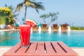 Healthy concept, Water melon smoothie on a wood table with swimming pool and blue sky background