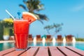 Healthy concept, Water melon smoothie on a wood table with swimming pool and blue sky background Royalty Free Stock Photo