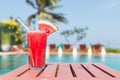 Healthy concept, Water melon smoothie on a wood table with swimming pool and blue sky background Royalty Free Stock Photo