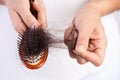 Healthy concept. Woman show her brush with damaged long loss hair and looking at her hair