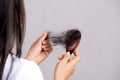 Healthy concept. Woman show her brush with damaged long loss hair and looking at her hair Royalty Free Stock Photo