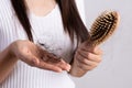 Healthy concept. Woman show her brush with damaged long loss hair and looking at her hair Royalty Free Stock Photo