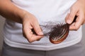 Healthy concept. Woman show her brush with long loss hair and looking at her hair Royalty Free Stock Photo