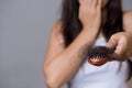 Healthy concept. Woman show her brush with long loss hair and looking at her hair Royalty Free Stock Photo